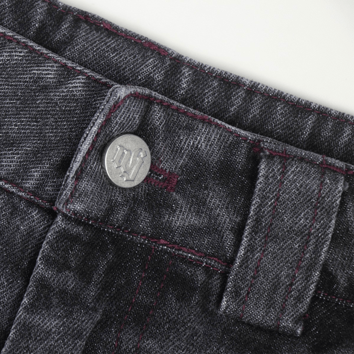 Stone-washed denim jorts with wine red stitching and chrome leather patch by WOJO